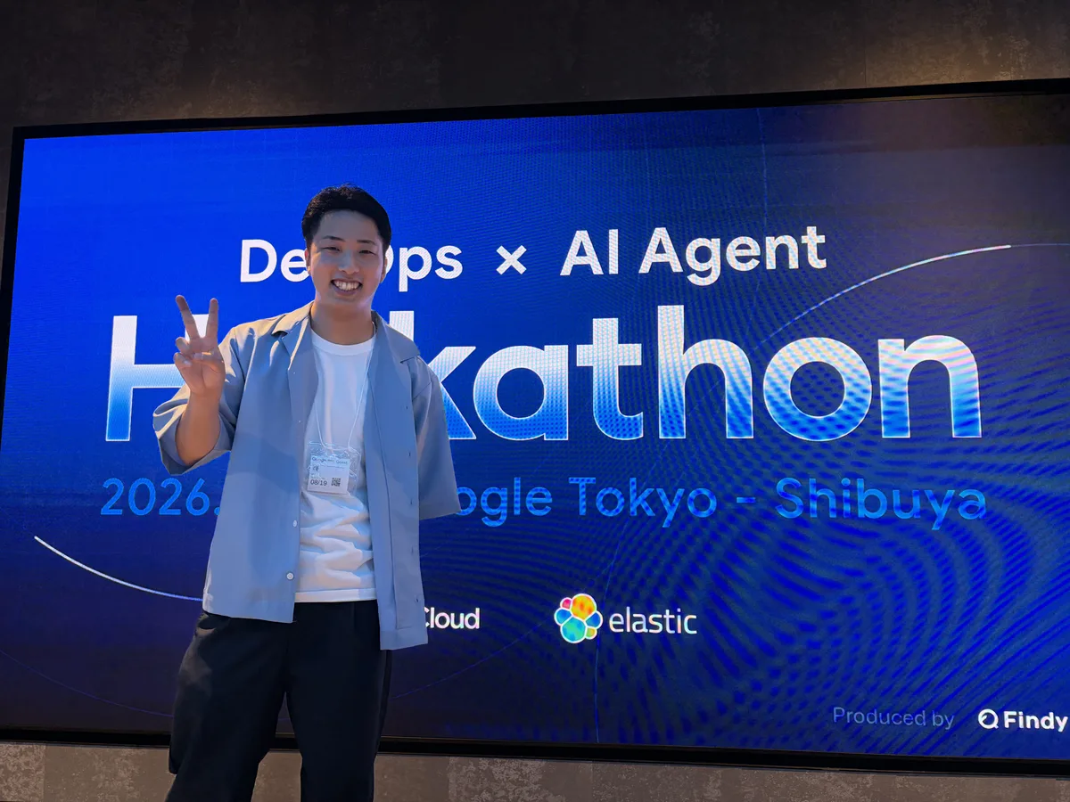 筆者と、「DevOps × AI Agent Hackathon(Google Tokyo・Findy 主催)」の看板。決勝を見に行ってきました。